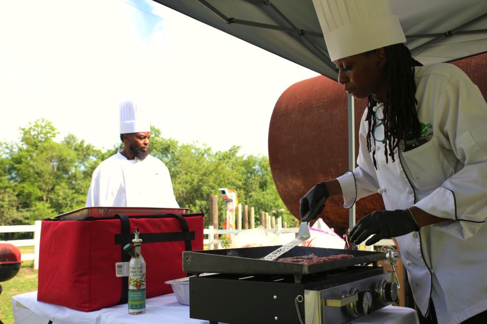 Chef Curtis Washington (left) and Chef Taylor (right) of 2 Chefs Gullah Geechee preparing food for the dinner at the Forsyth Farmers' Market 15th anniversery Farm-R-Que on Sunday, April 28.