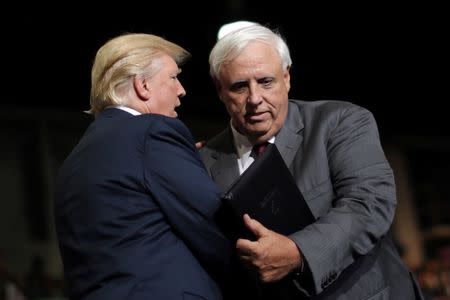 President Trump talks with West Virginia's Democratic Governor Jim Justice after he announced that he is changing parties during a rally in Huntington, West Virginia. REUTERS/Carlos Barria