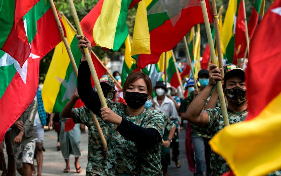 Military supporters carry Myanmar's national flags - SAI AUNG MAIN/AFP