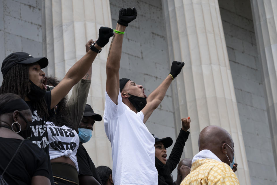 People raise their fists during the March on Washington, Friday Aug. 28, 2020, at the Lincoln Memorial in Washington, on the 57th anniversary of the Rev. Martin Luther King Jr.'s "I Have A Dream" speech. (AP Photo/Alex Brandon)