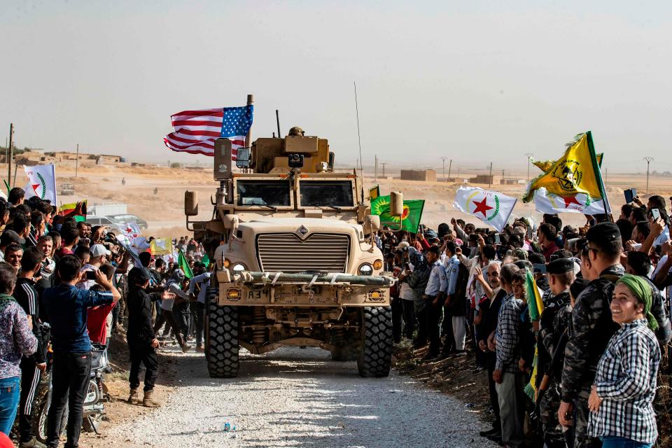 Syrian Kurds gather around a U.S. military vehicle on Oct. 6, 2019, near the Turkish border.