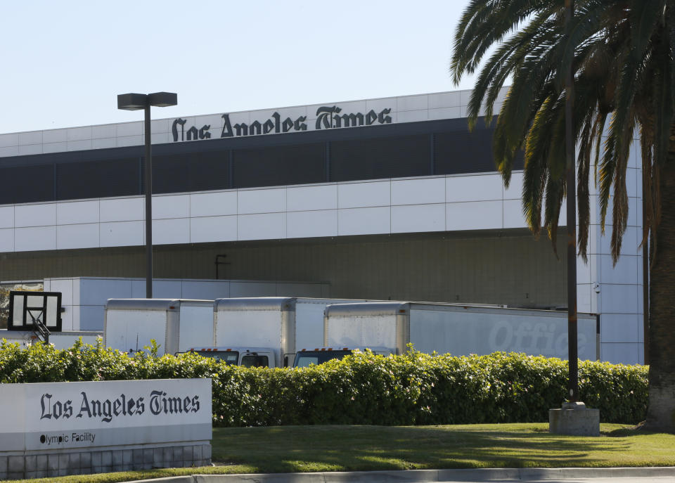 Delivery trucks are parked outside the Los Angeles Times Olympic Facility in Los Angeles, Sunday, Dec. 30, 2018. A computer virus hit the newspaper printing plant in Los Angeles, and at Tribune Publishing newspapers across the country. (AP Photo/Damian Dovarganes)