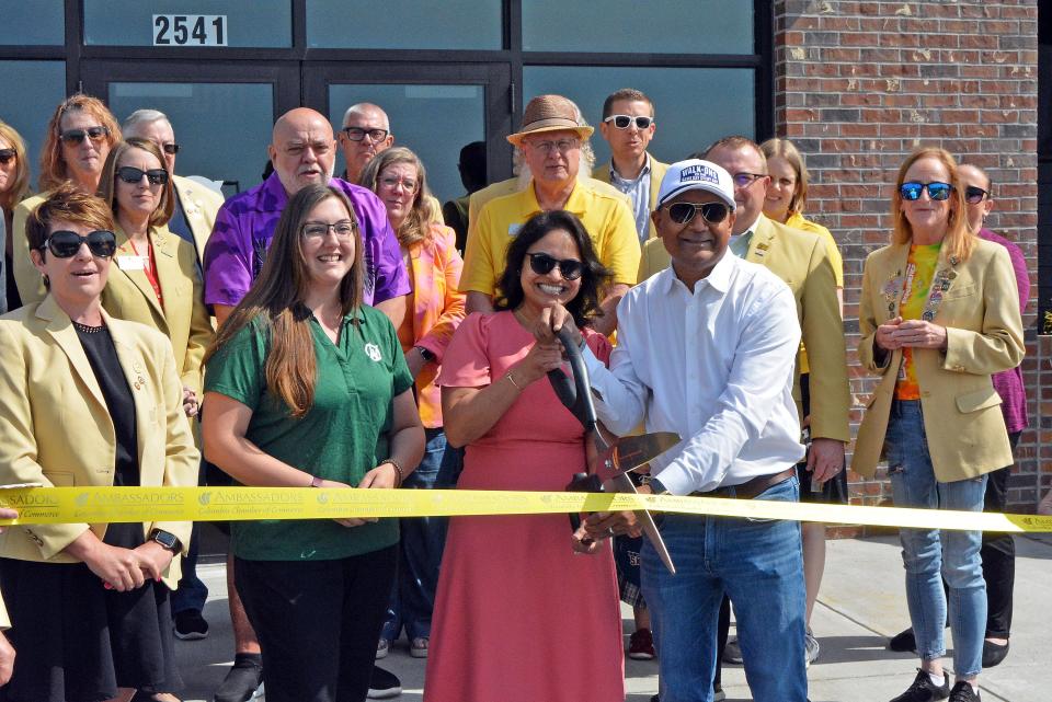 Walk-ons Sports Bistreaux franchise owners Sefali and AJ Nursariwala, third and fourth from left, prepare to cut the ribbon Monday on the new Columbia restaurant at the former location of Houlihan's at 2541 Broadway Bluff Drive. They are joined by Michelle Noe, general manager, second from left, and the Columbia Chamber of Commerce ambassadors. 