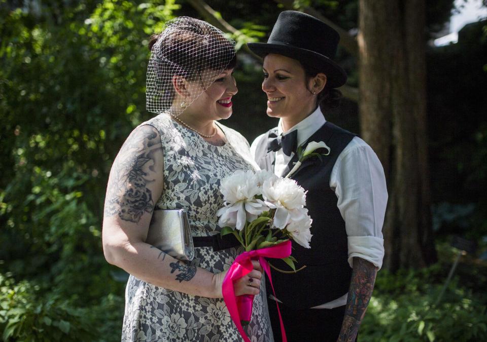 May (R) and Michelle Brand pose for a picture before "The Celebration of Love", a grand wedding where over 100 LGBT couples got married, at Casa Loma in Toronto