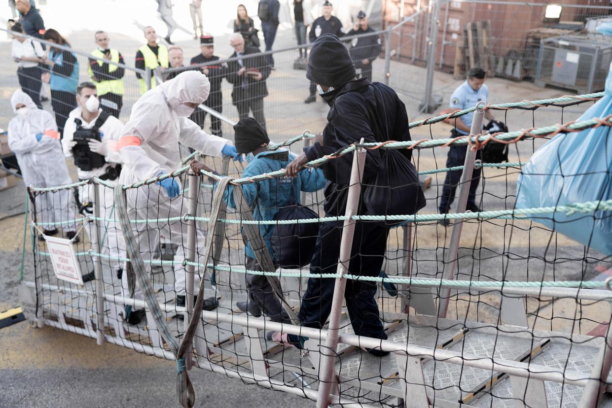 Two migrants disembark a ship called the Ocean Viking.