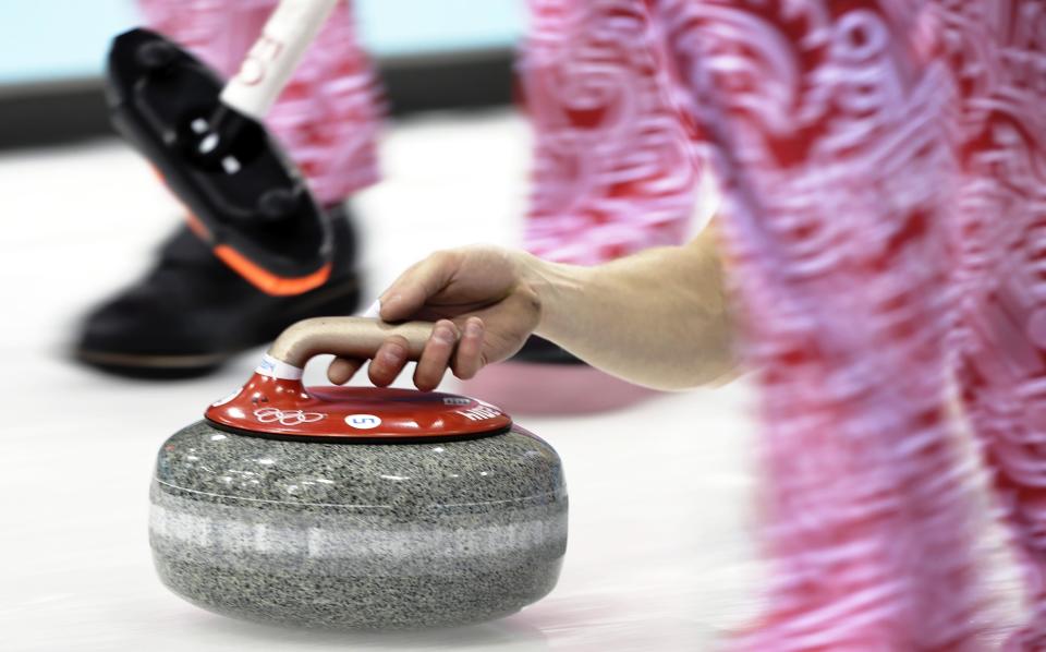 Russia's Evgeny Arkhipov delivers the rock during the men's curling competition against China at the 2014 Winter Olympics, Saturday, Feb. 15, 2014, in Sochi, Russia.