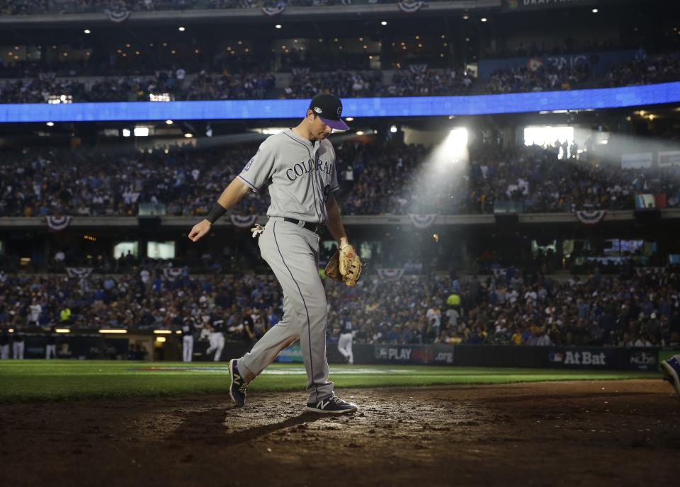 Colorado Rockies second baseman DJ LeMahieu walks off the field at the end of the fourth inning of Game 1 of the National League Divisional Series baseball game against the Milwaukee Brewers Thursday, Oct. 4, 2018, in Milwaukee. (AP Photo/Jeff Roberson)