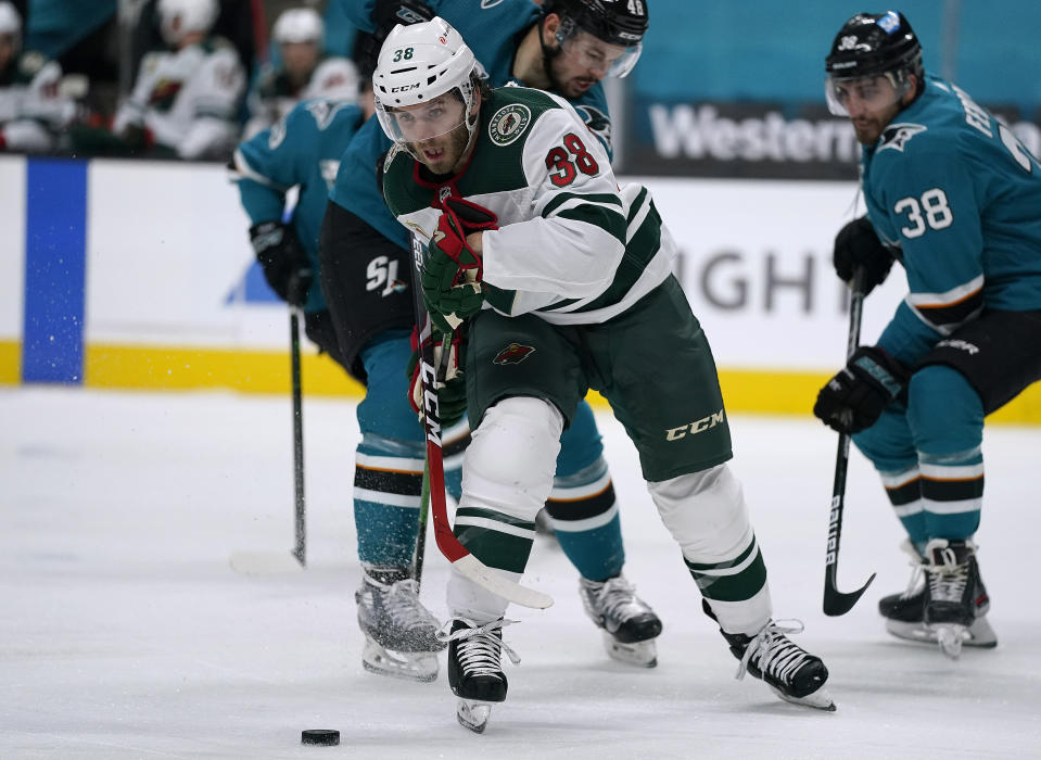 Minnesota Wild right wing Ryan Hartman (38) moves the puck past San Jose Sharks center Tomas Hertl (48) during the second period of an NHL hockey game in San Jose, Calif., Monday, March 29, 2021. (AP Photo/Tony Avelar)