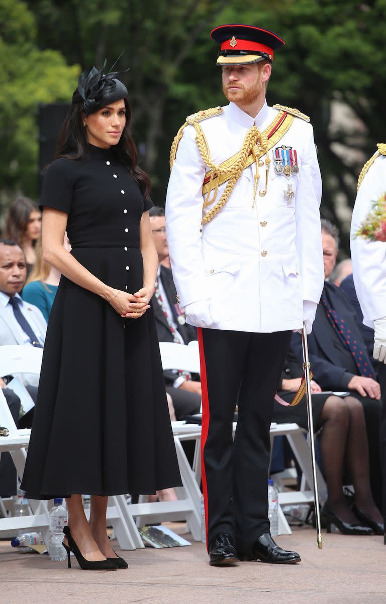 <p>For the opening of the ANZAC memorial, Meghan stunned in an elegant black <a href="https://www.net-a-porter.com/gb/en/product/1066210?cm_mmc=LinkshareUK-_-TnL5HPStwNw-_-Custom-_-LinkBuilder&siteID=TnL5HPStwNw-BpEk7gKuIC19f6zEoTwtog&Skimlinks.com=Skimlinks.com&dclid=CjkKEQjw6rXeBRCUls2ToN36kPwBEiQAY8wDXdiO7vjVdUY91ROTWAvSWehqsSk0T-r_harJITRjHZjw_wcB" rel="nofollow noopener" target="_blank" data-ylk="slk:Emilia Wickstead dress;elm:context_link;itc:0;sec:content-canvas" class="link ">Emilia Wickstead dress</a> featuring white buttons. She accessorised the look with a black <a href="https://www.net-a-porter.com/gb/en/Shop/Designers/Philip_Treacy?pn=1&npp=60&image_view=product&dScroll=0&cm_mmc=LinkshareUK-_-TnL5HPStwNw-_-Custom-_-LinkBuilder&siteID=TnL5HPStwNw-52mv6eR7UDkzs6F3RKSjfQ&Skimlinks.com=Skimlinks.com&dclid=CjkKEQjw6rXeBRCUls2ToN36kPwBEiQAY8wDXSZdK6_mkUvuu4OjOF61mT9PJq9uCuK9rO0ADq528Jbw_wcB" rel="nofollow noopener" target="_blank" data-ylk="slk:Philip Treacy hat;elm:context_link;itc:0;sec:content-canvas" class="link ">Philip Treacy hat</a> and a matching clutch bag. </p>