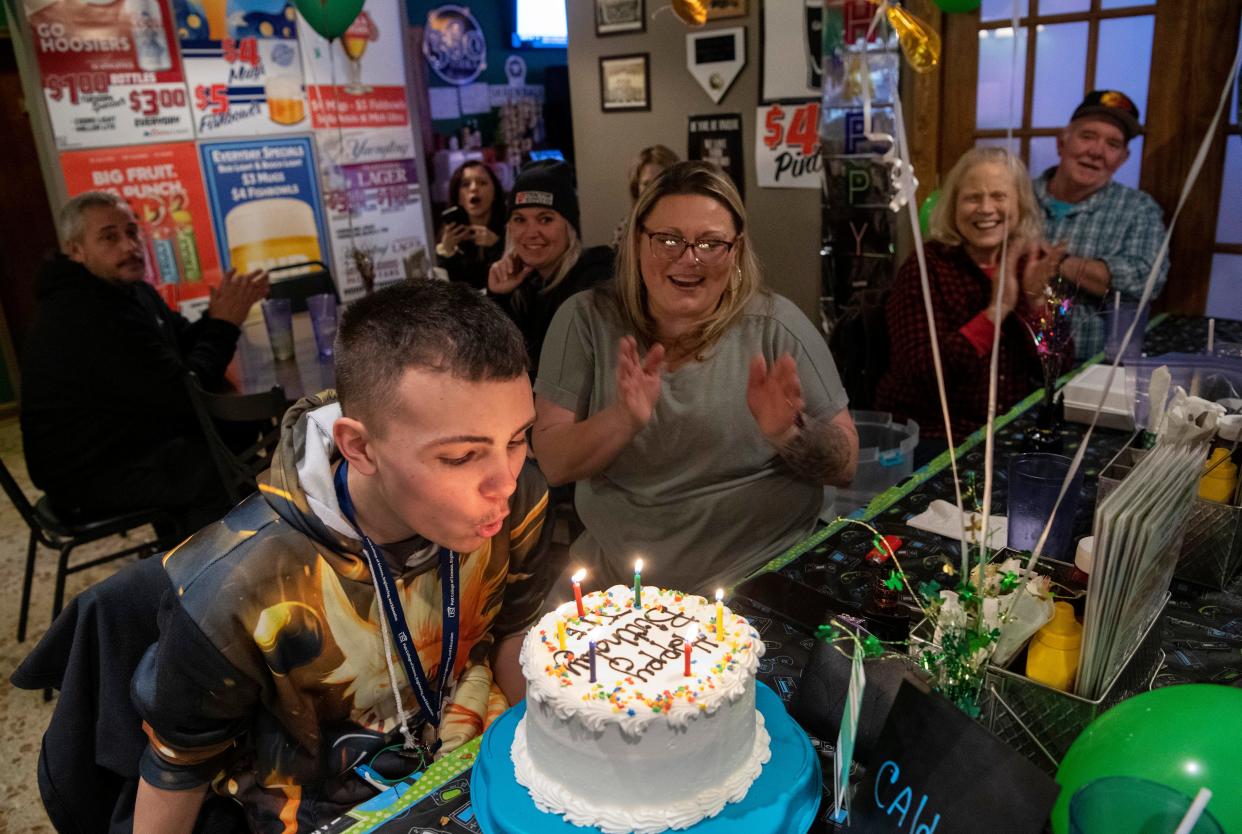 Tre Schapker blows out the candles on his triple-decker birthday cake during his party at Froggy's Restaurant in Wadesville, Ind., Friday night, Jan. 20, 2023. His mom, Autumn Cardwell, center, is a professional cake baker and Tre polished-off two pieces before the wax on the candles got cold. Tre was 11 years old when he was diagnosed with a rare form of juvenile cancer and has been undergoing treatment ever since.