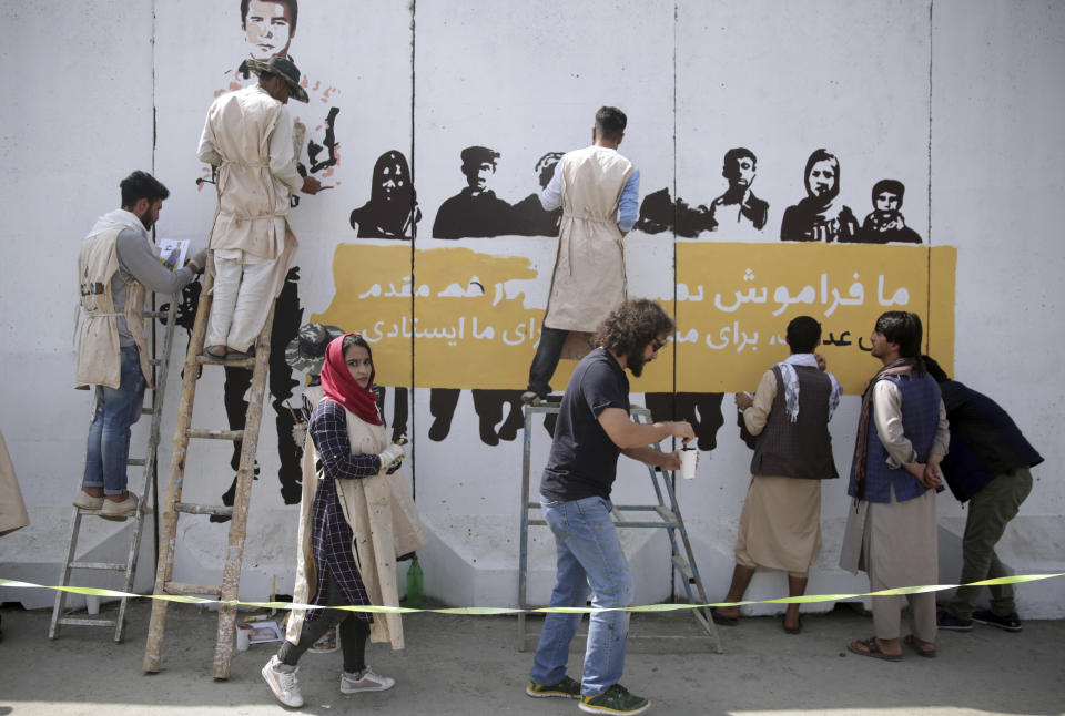 Artists from ArtLords organization, paint a mural of journalists who have been killed during the year of 2018, in Kabul, Afghanistan, Tuesday, Sept. 25, 2018. It's the first in a series of murals planned by Amnesty International and the Artlords collective to highlight the work of Afghan activists, teachers, lawyers, students, trade unionists and others. (AP Photo/Massoud Hossaini)