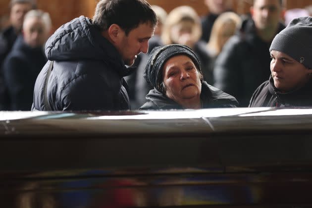 The mother of a Ukrainian boxing coach killed in a Jan. 17 Russian missile strike in Dnipro, Ukraine, grieves at her son's coffin.