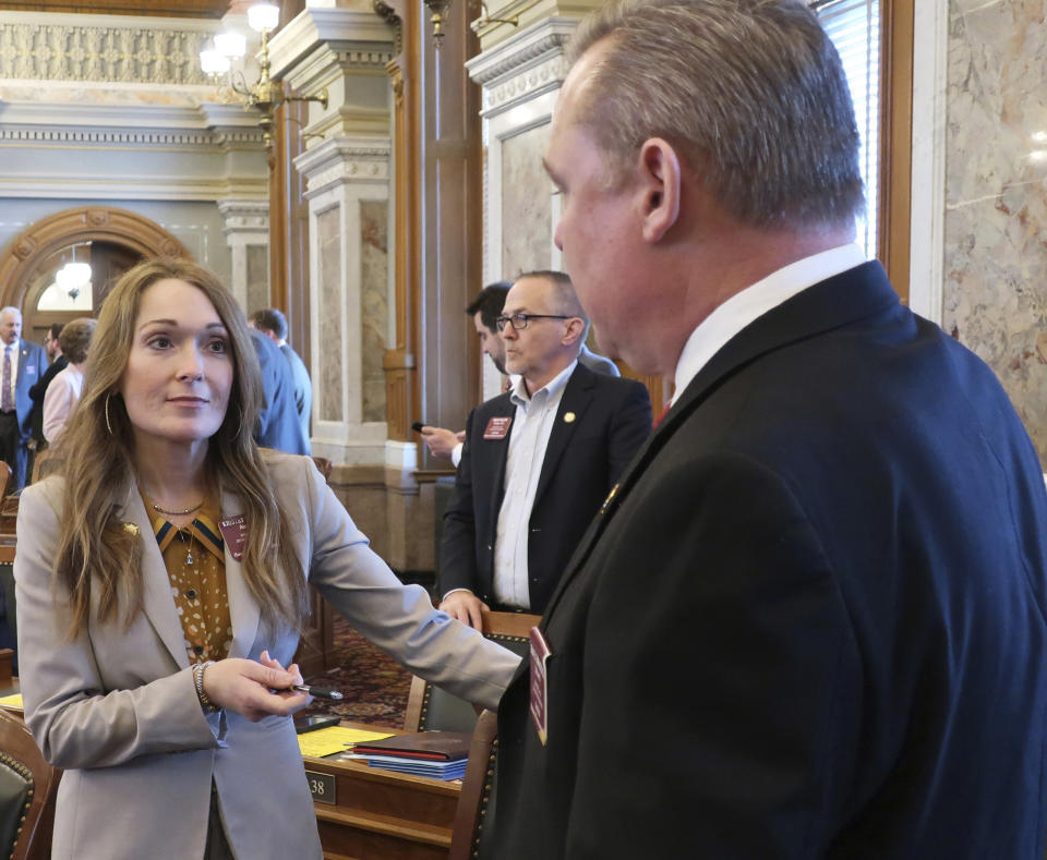 Kansas state Rep. Kristey Williams, left, R-Augusta, the chairwoman of a committee on education funding, confers with Rep. Sean Tarwater, R-Stilwell, before the House's daily session, Thursday, Aug. 4, 2019, at the Statehouse in Topeka, Kan. Lawmakers are not sure Democratic Gov. Laura Kelly's proposal to boost spending on public schools will be enough to satisfy a Kansas Supreme Court mandate. (AP Photo/John Hanna)