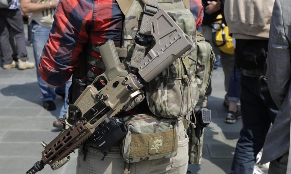 A man standing with members of Patriot Prayer and other groups supporting gun rights wears guns during a rally on Saturday at City Hall in Seattle.