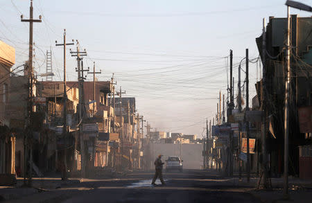 A man walks across a street in Qaraqosh, east of Mosul, Iraq November 25, 2016. REUTERS/Goran Tomasevic