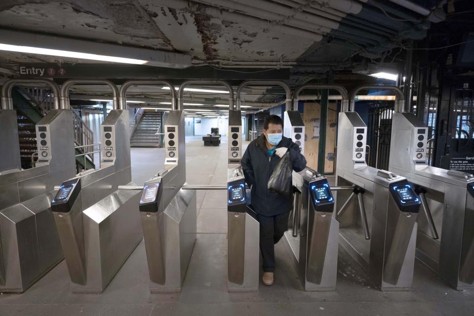FILE - In this April 23, 2020, file photo, man leaves a quiet 61st Street–Woodside subway station in the Queens borough of New York. Public transit systems nationwide are grappling with plummeting ridership and revenue during the coronavirus pandemic. (AP Photo/Mark Lennihan, File)