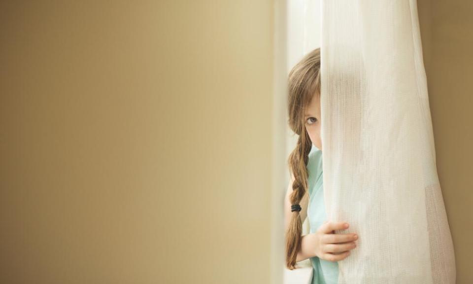 Shy girl peeking around curtain