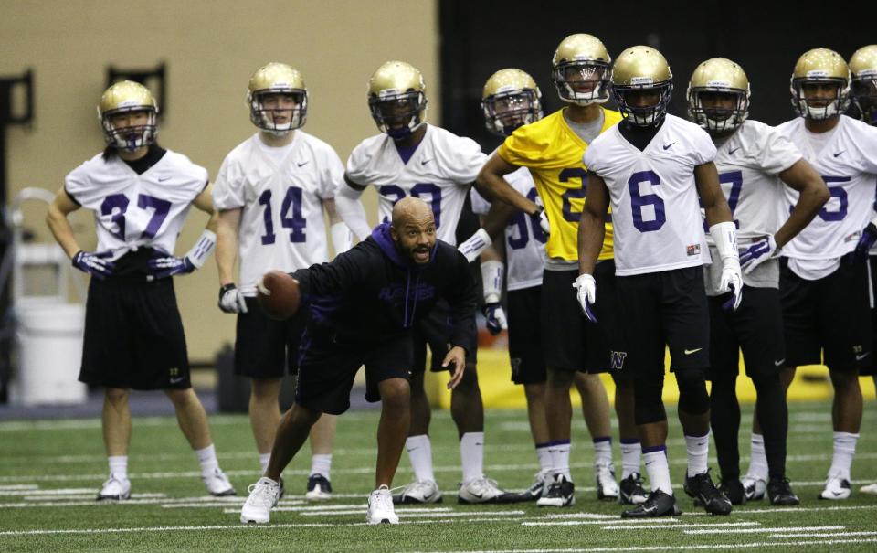 Washington defensive backs coach Jimmy Lake takes his players through a drill on the first day of spring NCAA college football practice, Tuesday, March 4, 2014 in Seattle. (AP Photo/Ted S. Warren)