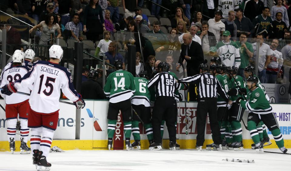Columbus Blue Jackets and Dallas Stars players rush to the bench in the first period of an NHL Hockey game Monday, March 10, 2014, in Dallas. Stars center Rich Peverly was transported to the hospital after play was suspended. (AP Photo/Sharon Ellman)