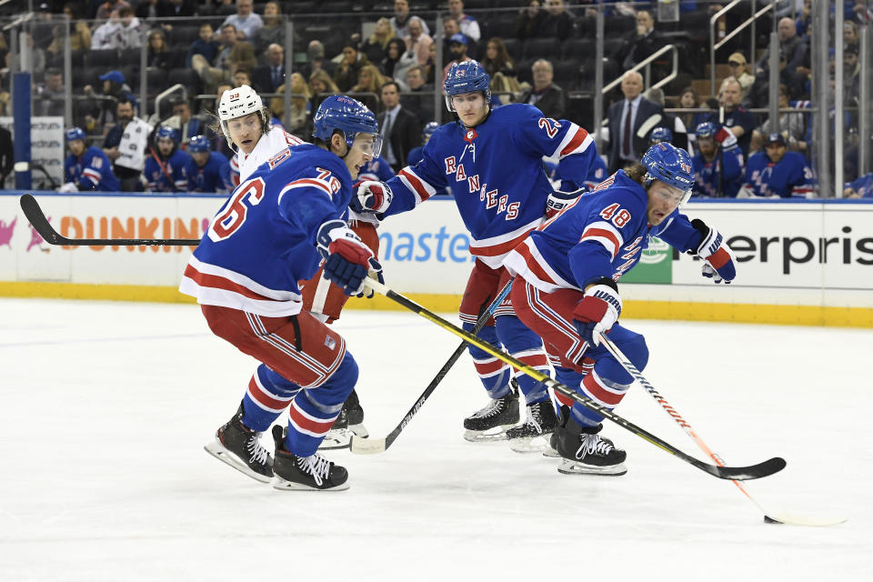 New York Rangers left wing Brendan Lemieux (48) reaches for the puck near defensemen Brady Skjei (76) and Adam Fox (23) and Detroit Red Wings left wing Tyler Bertuzzi (59) during the first period of an NHL hockey game Friday, Jan. 31, 2020, in New York. (AP Photo/Sarah Stier)