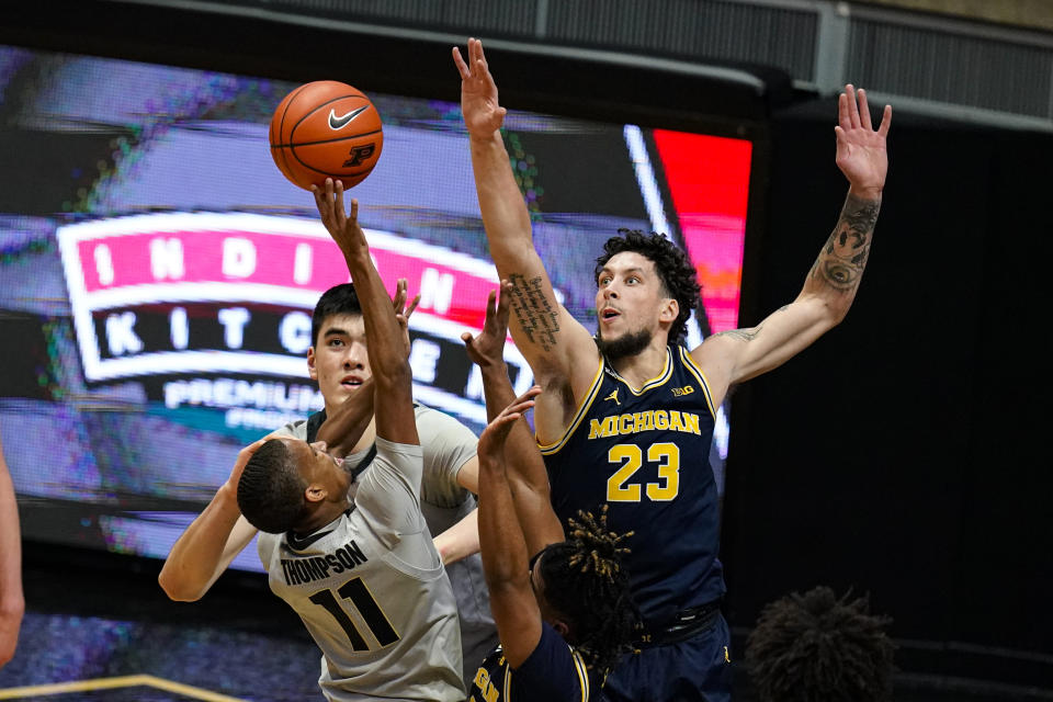 Michigan forward Brandon Johns Jr. (23) goes up to block the shot of Purdue guard Isaiah Thompson (11) during the first half of an NCAA college basketball game in West Lafayette, Ind., Friday, Jan. 22, 2021. (AP Photo/Michael Conroy)