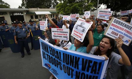 Protesters march past the policemen during a rally against the killing of 26-year-old Filipino transgender Jennifer Laude, outside the U.S. embassy in Manila October 17, 2014. REUTERS/Erik De Castro