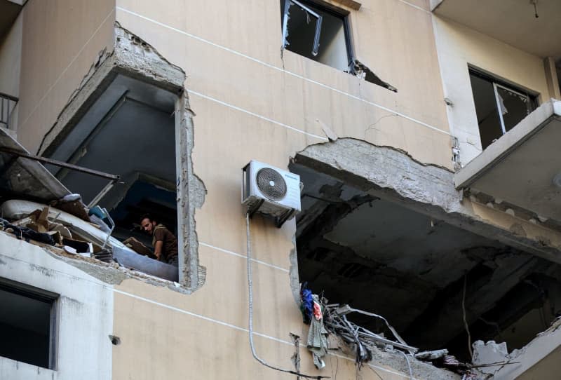 A Lebanese civil defense worker search in rubble and debris of an apartment in a building was targeted by an Israeli air strike in Beirut’s southern suburb. The attack targeted a top pro-Iranian Hezbollah commander. Marwan Naamani/dpa