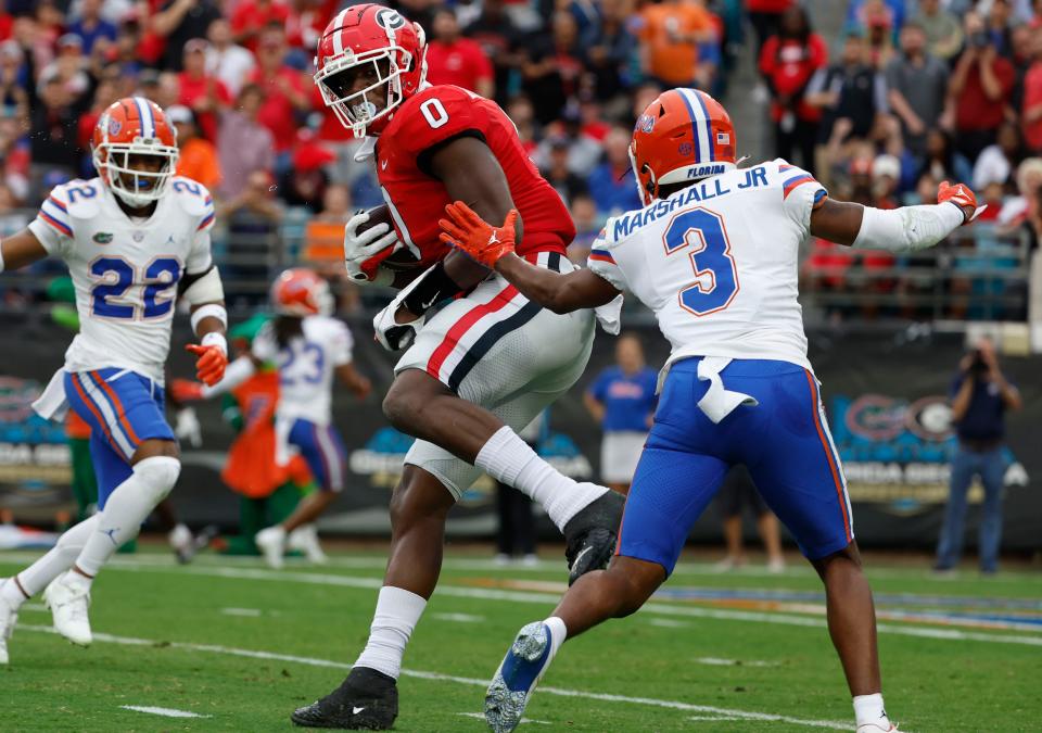 Georgia tight end Darnell Washington (0) runs with the ball while Florida cornerback Jason Marshall Jr. (3) defends during the first quarter at TIAA Bank Field.