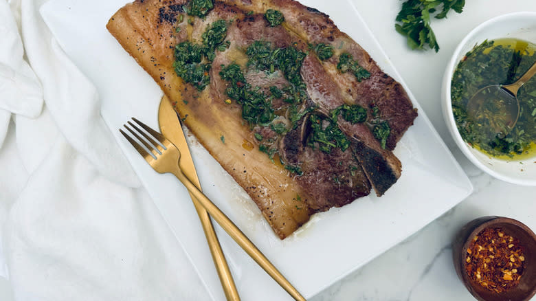 pork steak with chimichurri on white plate