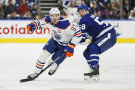 Edmonton Oilers center Connor McDavid (97) skates by Toronto Maple Leafs left wing Michael Bunting (58) during the third period of an NHL hockey game Saturday, March 11, 2023, in Toronto. (Cole Burston/The Canadian Press via AP)