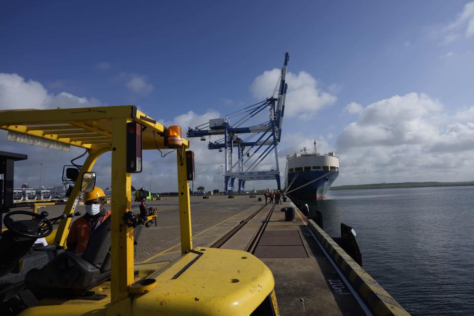 A Sri Lankan port worker stands on jetty at the Chinese run International Port in Hambantota, Sri Lanka, Tuesday, Aug. 16, 2022. China has lent Sri Lanka billions of dollars for development projects, which include the Hambantota port, which Sri Lanka leased to China in 2017 because it could not pay back the loan. (AP Photo/Eranga Jayawardena)