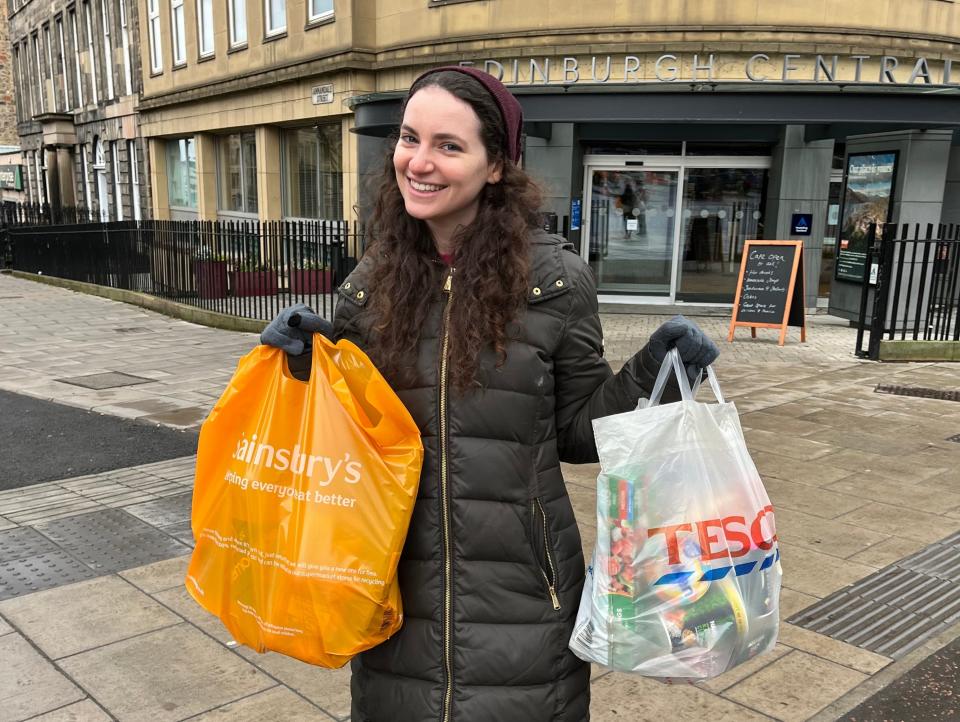 Insider reporter holding a Tesco and a Sainbury's bag