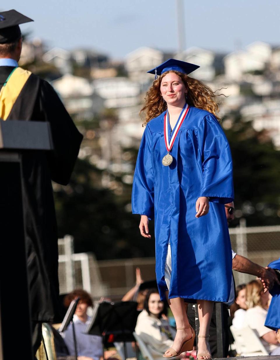 At Morro Bay High School, 180 grads were honored Thursday evening in a ceremony at the school’s football field. Salutatorian Rae Ruane walks up to receive her diploma.