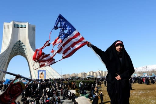 An Iranian woman marks the 41st anniversary of the Islamic republic by burning the US flag in Tehran's Azadi Square
