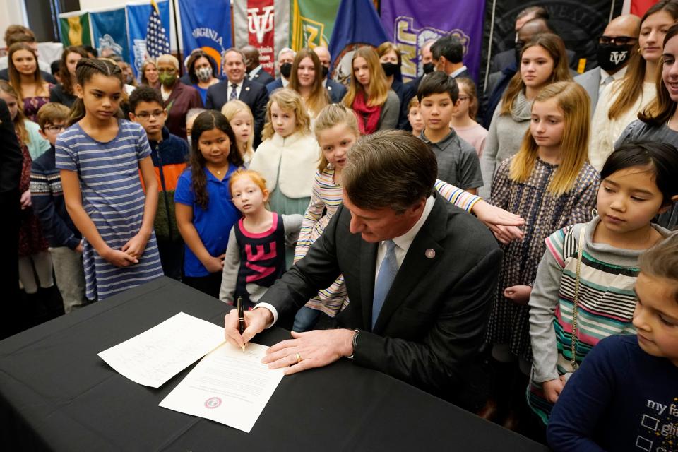 Virginia Gov. Glenn Youngkin signs an executive order establishing lab schools while surrounded by children and educators at the Capitol Thursday in Richmond.