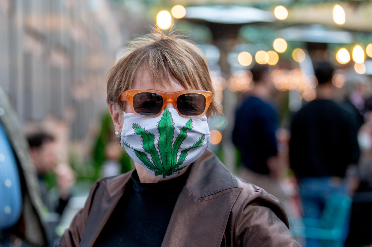 A woman with a cannabis-themed face mask celebrates the 50th anniversary of 420 and the legalization of marijuana in New York on April 20, 2021 in New York City. (Photo by Roy Rochlin/Getty Images)