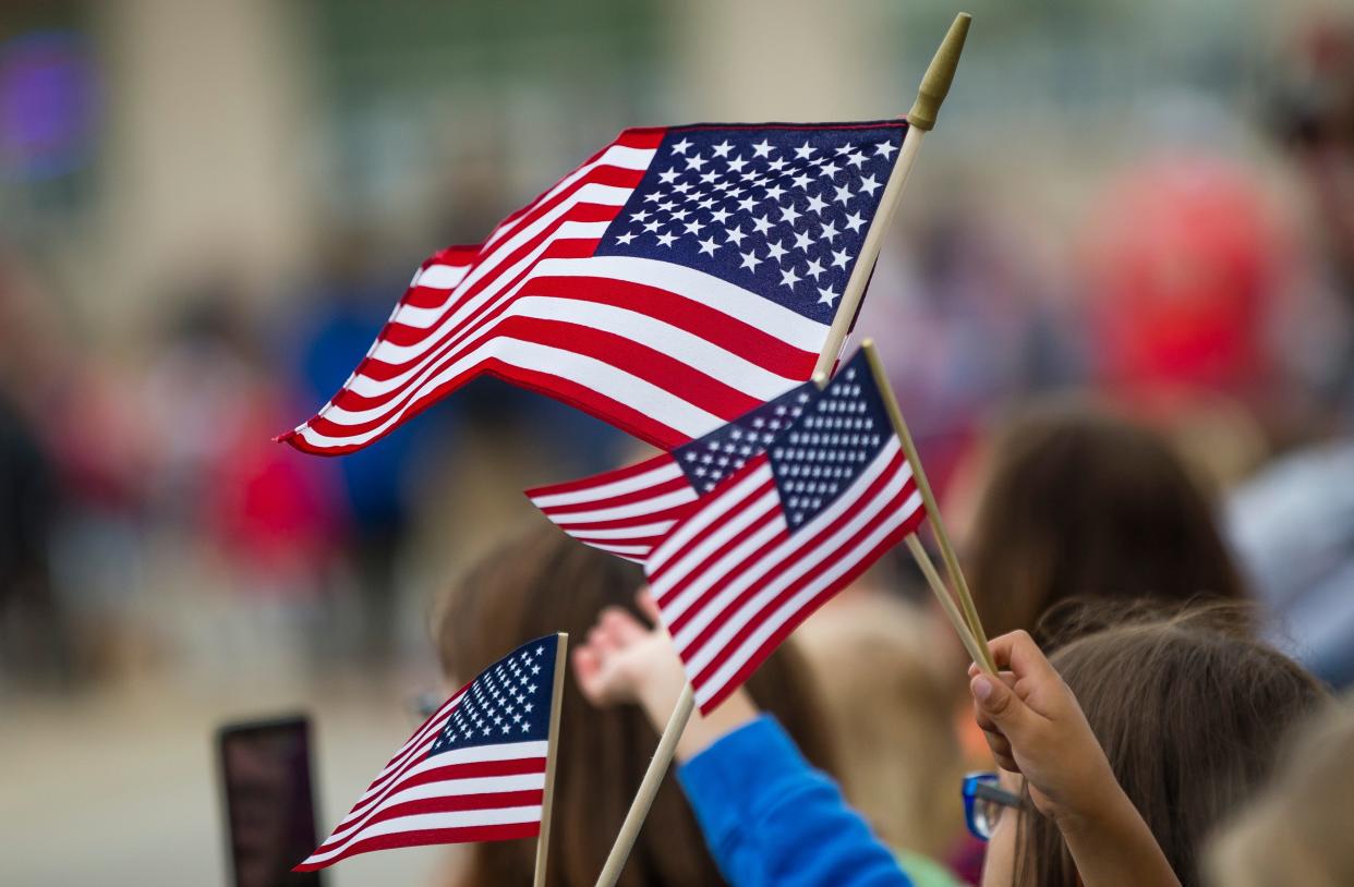 People wave flags May 27, 2019, during the Mishawaka Memorial Day Parade in downtown Mishawaka.