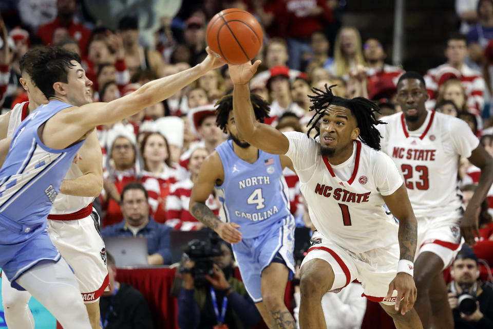 North Carolina's Cormac Ryan, left, tips the ball away from North Carolina State's Jayden Taylor (1) during the second half of an NCAA college basketball game in Raleigh, N.C., Wednesday, Jan. 10, 2024. (AP Photo/Karl B DeBlaker)