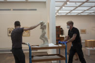 Israel Museum staff move Auguste Rodin's "Eve," back into a gallery during final preparations to reopen following five months of closure due to the coronavirus pandemic, in Jerusalem, Tuesday, Aug. 11, 2020. The Israel Museum, the country's largest cultural institution, is returning the priceless Dead Sea scrolls and other treasured artworks to its galleries ahead of this week's reopening to the public. (AP Photo/Maya Alleruzzo)