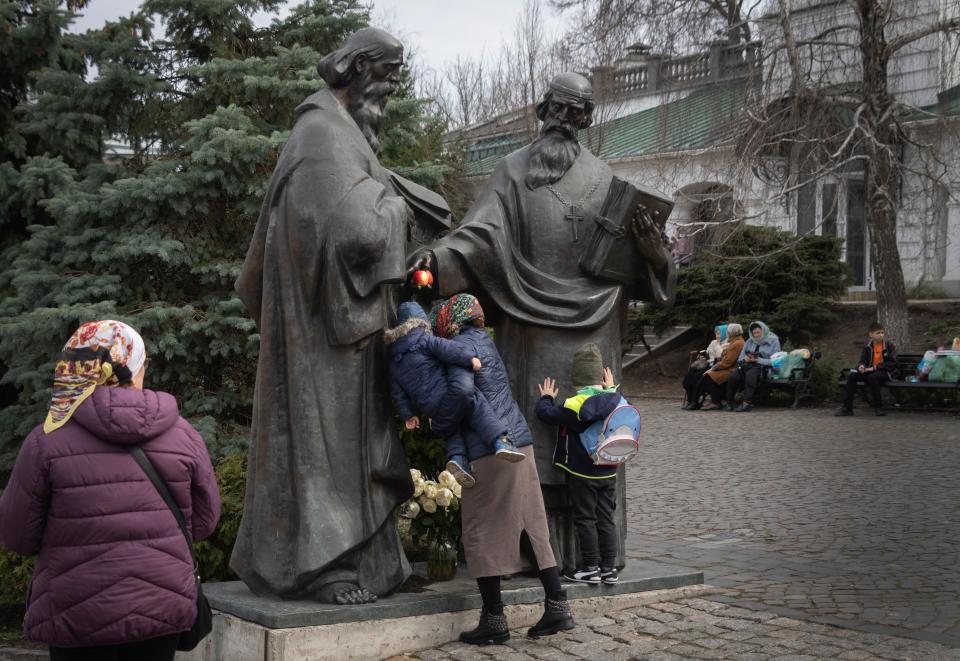 People pray at a sculpture of founding monks of the Monastery of the Caves, also known as Kyiv-Pechersk Lavra (Copyright 2023 The Associated Press. All rights reserved)