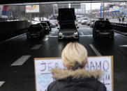 A demonstrator blocks a highway, during a protest in Belgrade, Serbia, Saturday, Jan. 15, 2022. Hundreds of environmental protesters demanding cancelation of any plans for lithium mining in Serbia took to the streets again, blocking roads and, for the first time, a border crossing. Traffic on the main highway north-south highway was halted on Saturday for more than one hour, along with several other roads throughout the country, including one on the border with Bosnia. (AP Photo/Darko Vojinovic)