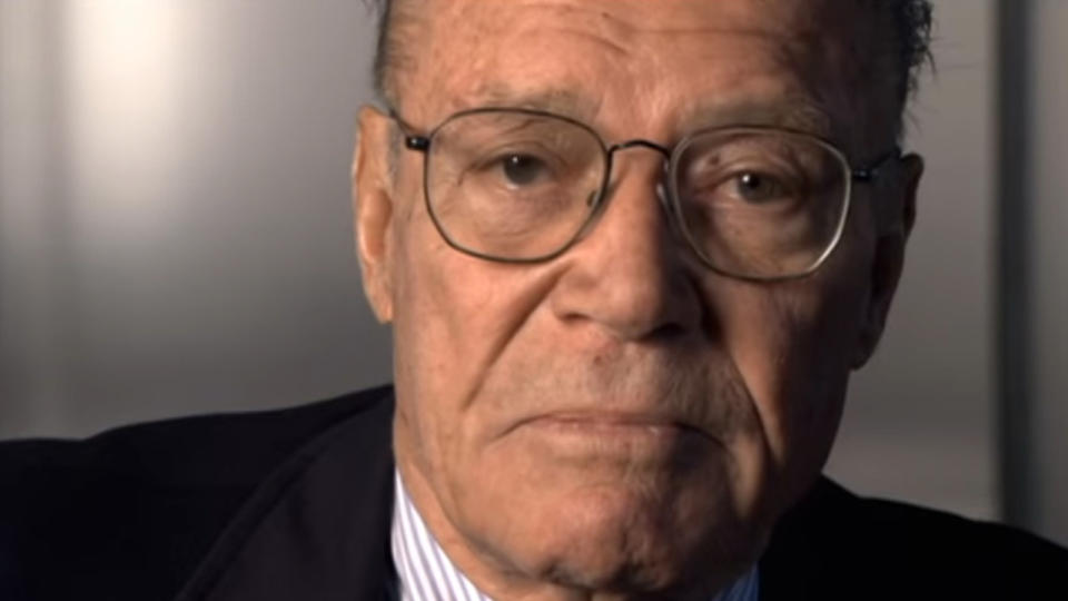 A close of up an older Robert McNamara being interviewed