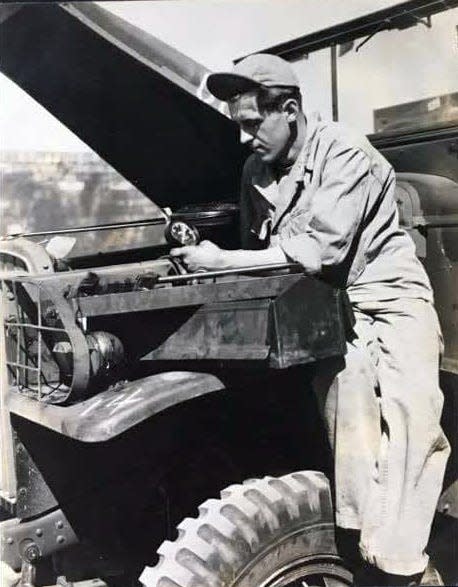 William Jacoby works on a vehicle during World War II.