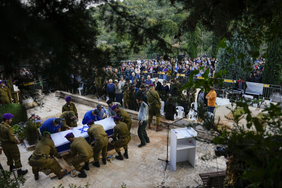 Israeli soldiers lower the coffin of American-Israeli reserve solider Sergeant first class Amichai Yisrael Yehoshua Oster into the grave during his funeral in the West Bank settlement of Karnei Shomron Tuesday, Jan. 2, 2024. Oster, 24, was killed during the Israeli military's ground operation in the Gaza Strip while the army is battling Palestinian militants in the war ignited by Hamas' Oct. 7 attack into Israel.(AP Photo/Ariel Schalit)