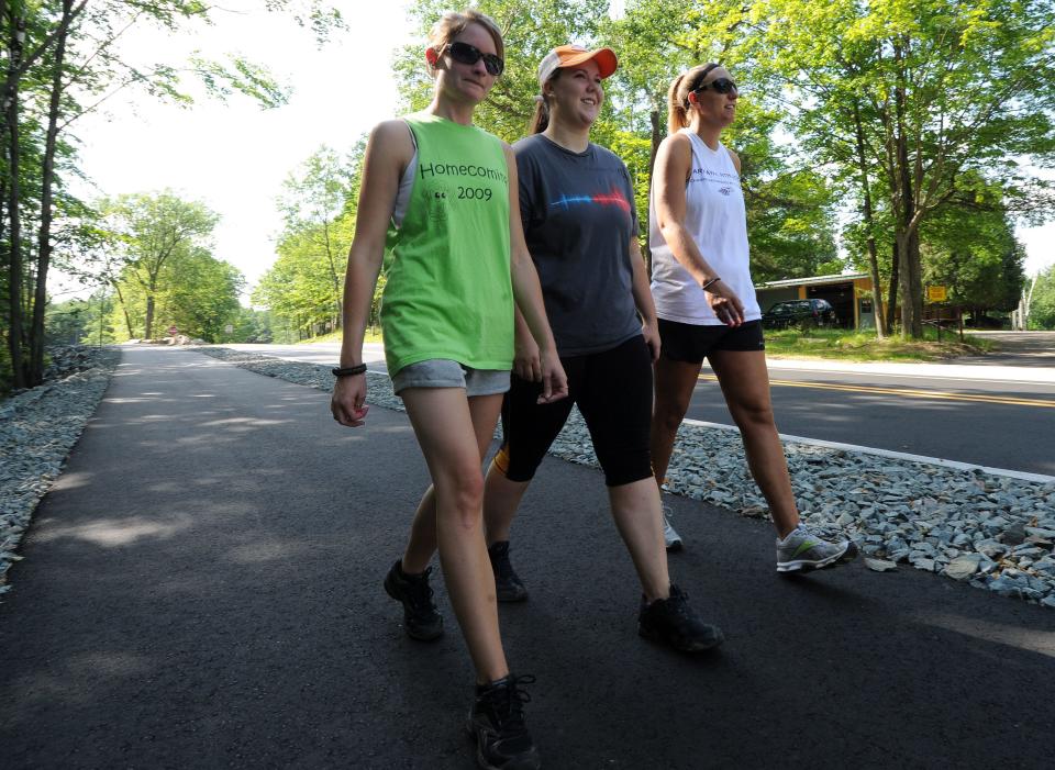 People walk on the paved pathway along the road leading to Rib Mountain State Park. The Wisconsin Department of Natural Resources is proposing a number of upgrades to the park including the addition of a multiuse paved trail around the base of Rib Mountain and mountain biking trails of various skill levels.