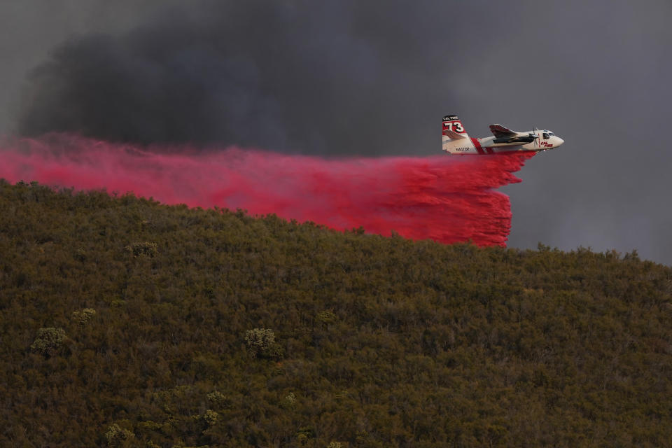 A plane drops fire retardant onto the advancing Route Fire Wednesday, Aug. 31, 2022, in Castaic, Calif. (AP Photo/Marcio Jose Sanchez)