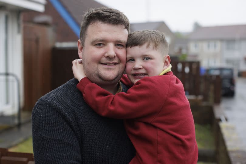 Mairtin Mac Gabhann, who has been made an MBE for services to organ donation in Northern Ireland, holding his son Daithi.