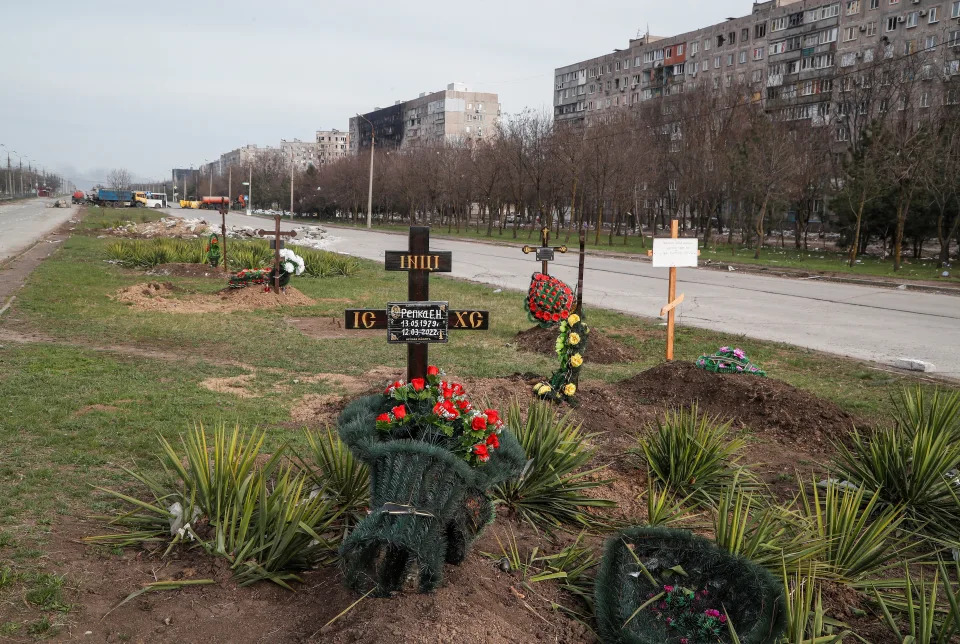 Graves of civilians killed during Ukraine-Russia conflict are seen next to apartment buildings in the southern port city of Mariupol, Ukraine April 10, 2022. REUTERS/Alexander Ermochenko
