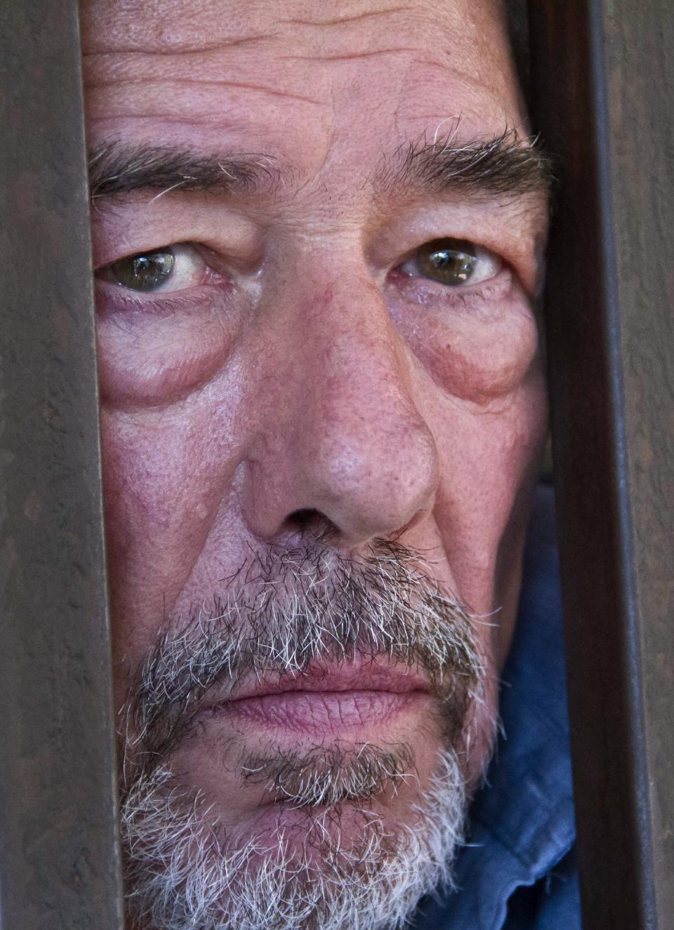 Briton Bernard Randall, 65, stands in a holding cell after a court hearing which ordered him to be deported, at the Chief Magistrates court in Entebbe, Uganda Wednesday, Jan. 22, 2014. A Ugandan court on Wednesday ordered the deportation of Randall who faced criminal charges following publication of images of him having sex with another man, in Uganda where homosexuality is illegal and lawmakers recently passed a draconian new bill that prescribes life imprisonment for "aggravated" homosexual acts. (AP Photo/Rebecca Vassie)