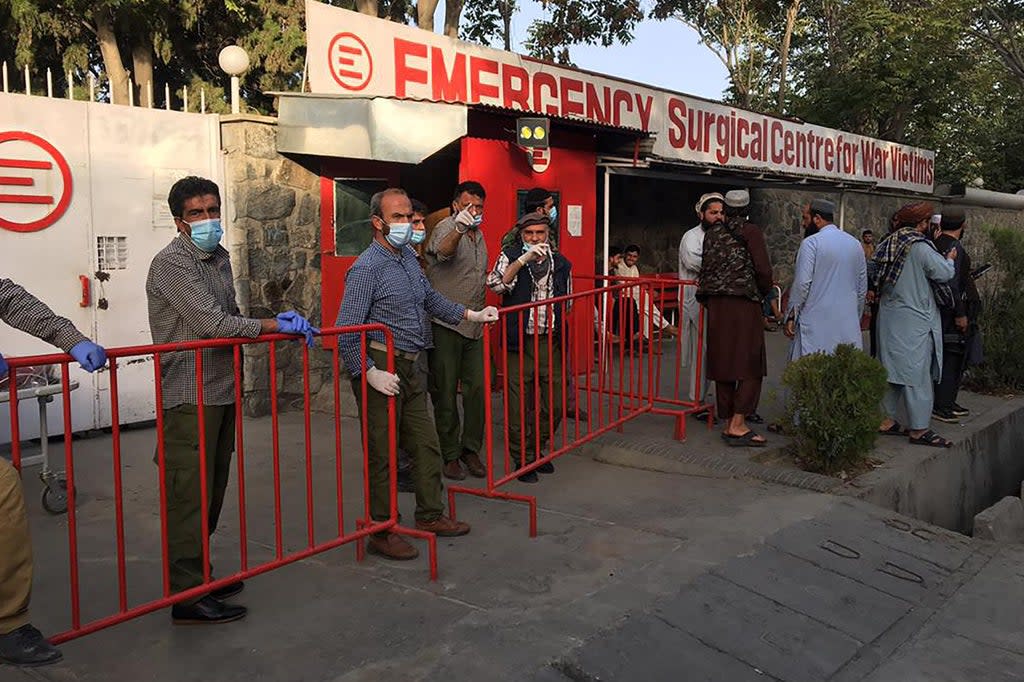 Afghan medical staff members stand at the entrance of a hospital as they wait to receive the victims of an explosion in Kabul  (AFP via Getty Images)